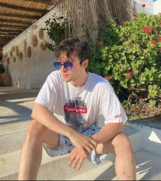 a man sitting on the steps wearing sunglasses