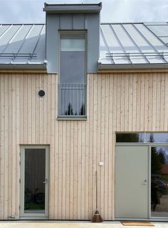 two doors are open in front of a building with a skylight on the roof