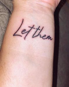 a wrist tattoo with the word let them written on it