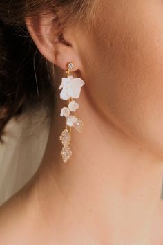 a woman wearing earrings with flowers on them