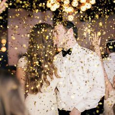 people are throwing confetti in the air as they dance together at a party