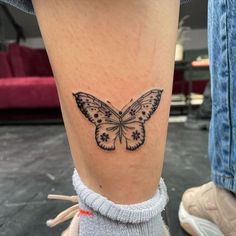 a small butterfly tattoo on the right ankle and leg, it is black and white