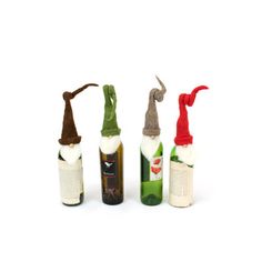 three wine bottles with hats on them and one bottle in the shape of an elf's hat