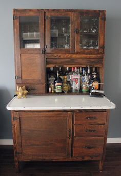 an old fashioned bar with liquor bottles and glasses on it's cabinet doors,