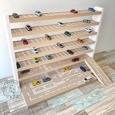 toy cars are lined up on shelves in the shape of a city street map for display