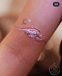 a woman's arm with a tattoo on it that is shaped like a fish