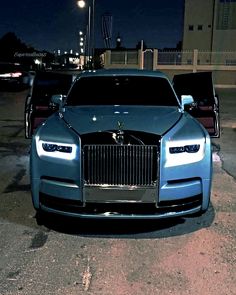 two rolls royces parked next to each other in a parking lot at night time