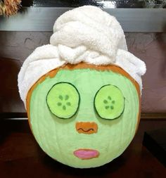 a green face with cucumber slices on it and a towel over its head