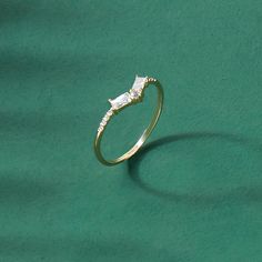 a gold ring with two diamonds on it