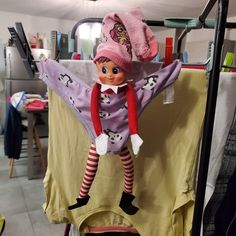 an elf doll hanging from a clothes rack