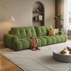 a living room with a green couch and coffee table in front of a large window