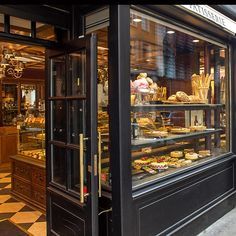 a bakery filled with lots of pastries on display in front of a store window