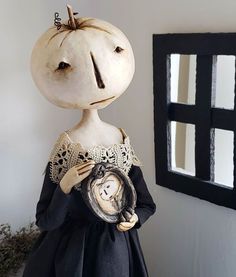 a creepy doll holding an old clock in her hands