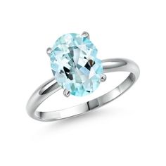 an oval aqua blue topazte ring on a white background with a diamond in the center