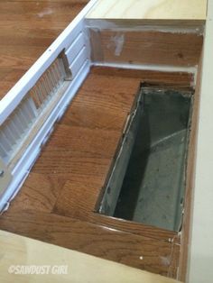 an open hole in the floor that is being installed on top of a wood floor