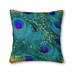 a blue and yellow pillow with lots of peacock feathers on it's back side