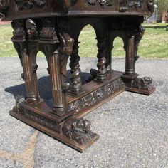 an ornately carved wooden table sitting on the ground