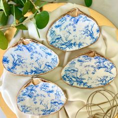 four blue and white plates sitting on top of a table