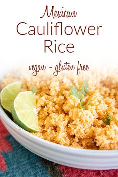 mexican cauliflower rice in a white bowl with lime wedges on the side