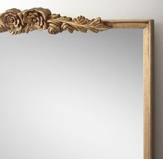 a mirror that is on the wall with a flower decoration around it's edge