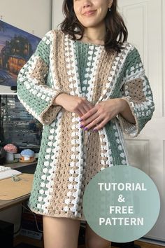 a woman standing in front of a desk wearing a crocheted sweater and shorts