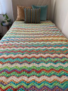 a crocheted bedspread with two pillows on it