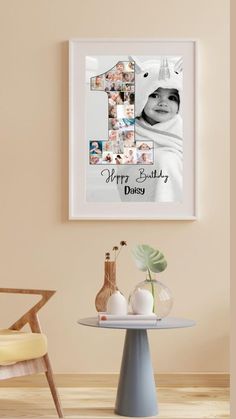 a baby's first birthday photo hanging on the wall next to a table and chair