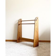 a wooden frame sitting on top of a carpeted floor next to a white wall