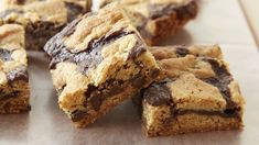 chocolate chip cookie bars cut into squares on top of parchment paper with one bite taken out