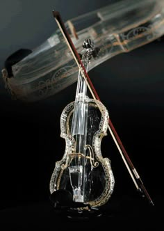 an old violin is sitting in front of a glass case