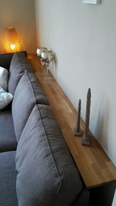 a couch sitting on top of a wooden shelf next to a lamp