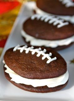 chocolate football cookies with white frosting on a plate