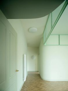 an empty hallway with white walls and wooden floors