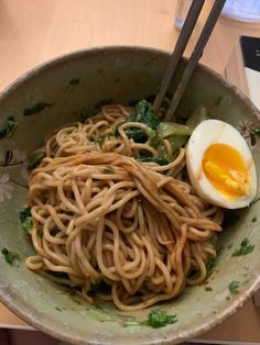 a bowl filled with noodles and an egg