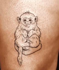 a small monkey tattoo on the back of a man's lower body and chest