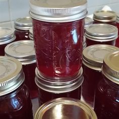 jars filled with red liquid sitting on top of a counter