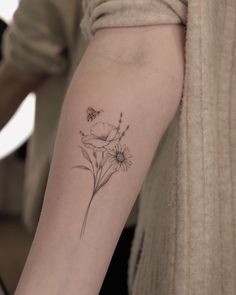 a woman's arm with a flower tattoo on the left side of her arm