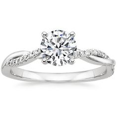 a white gold engagement ring with a twisted band and a round center diamond in the center