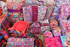 many colorful bags and wallets are stacked together