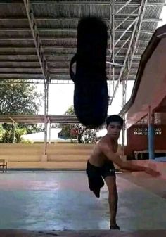 a shirtless man doing a handstand in an indoor gym