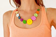 a woman in an orange tank top wearing a multicolored necklace with buttons on it