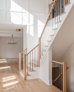 an empty room with white walls and wooden stairs