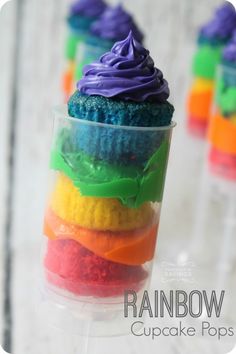 rainbow cupcakes in plastic cups with frosting on the top and colorful icing on the bottom