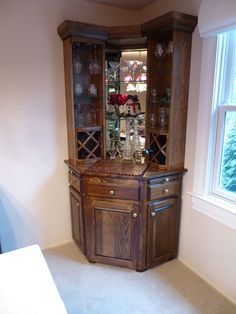 a wooden china cabinet with wine glasses in it