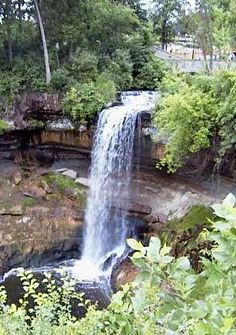 a large waterfall in the middle of a forest