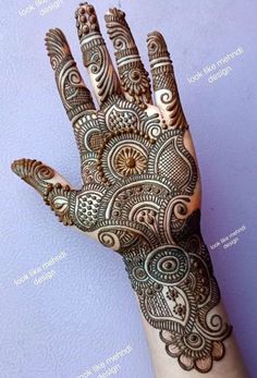 the hand is decorated with henna designs on it's fingers and hands, which are