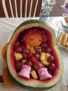 a watermelon shaped like a child's face with food in it