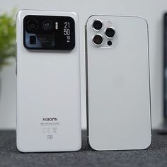 two white cell phones sitting next to each other