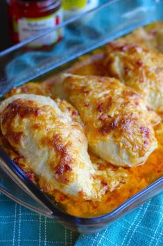 a casserole dish with chicken and cheese in it on a blue table cloth