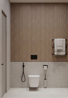 a white toilet sitting in a bathroom next to a wooden wall